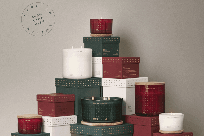 Several different sizes of Christmas-themed candles and boxes stacked in a beautiful pyramid