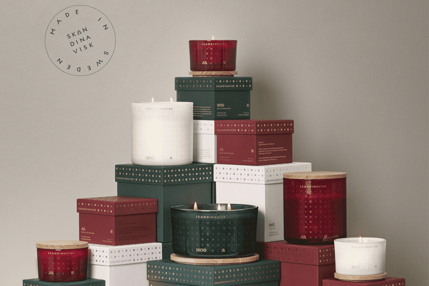 seasonals_collection_square Several different sizes of Christmas-themed candles and boxes stacked in a beautiful pyramid